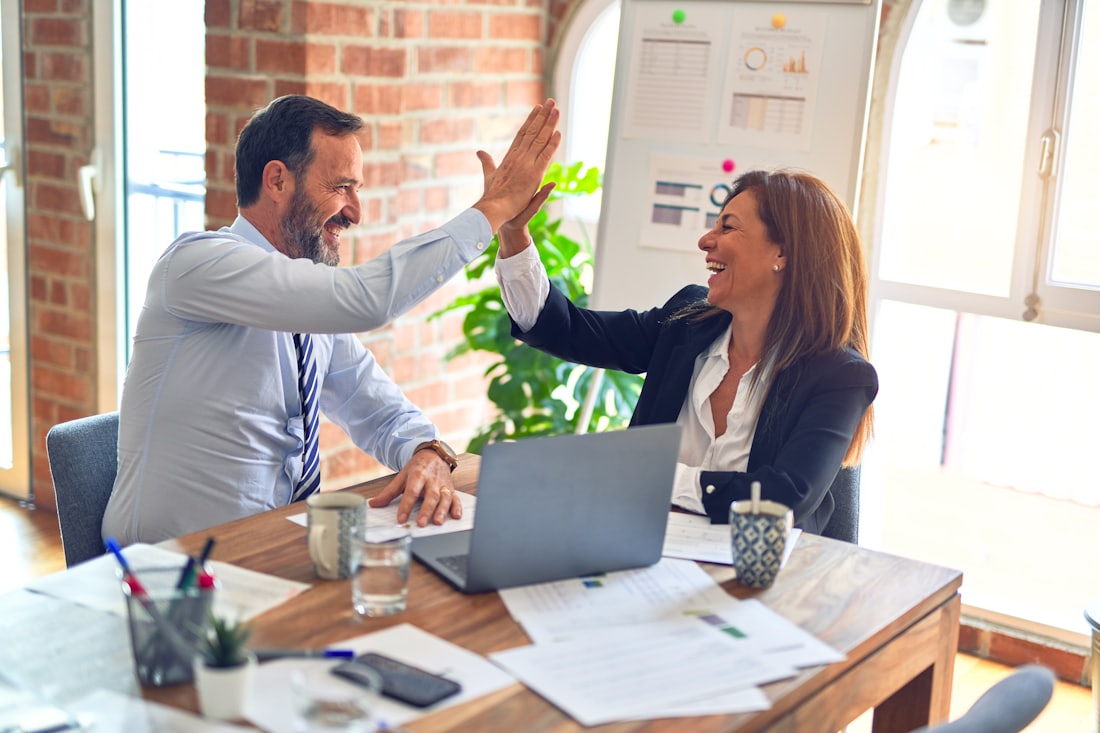 Two advisors working together at a desk in a bright office